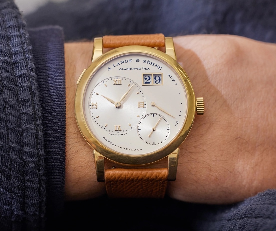 Перший серійний екземпляр Lange 1, референс 101.001, був представлений у 1994 році в корпусі з жовтого золота із циферблатом кольору шампань. 