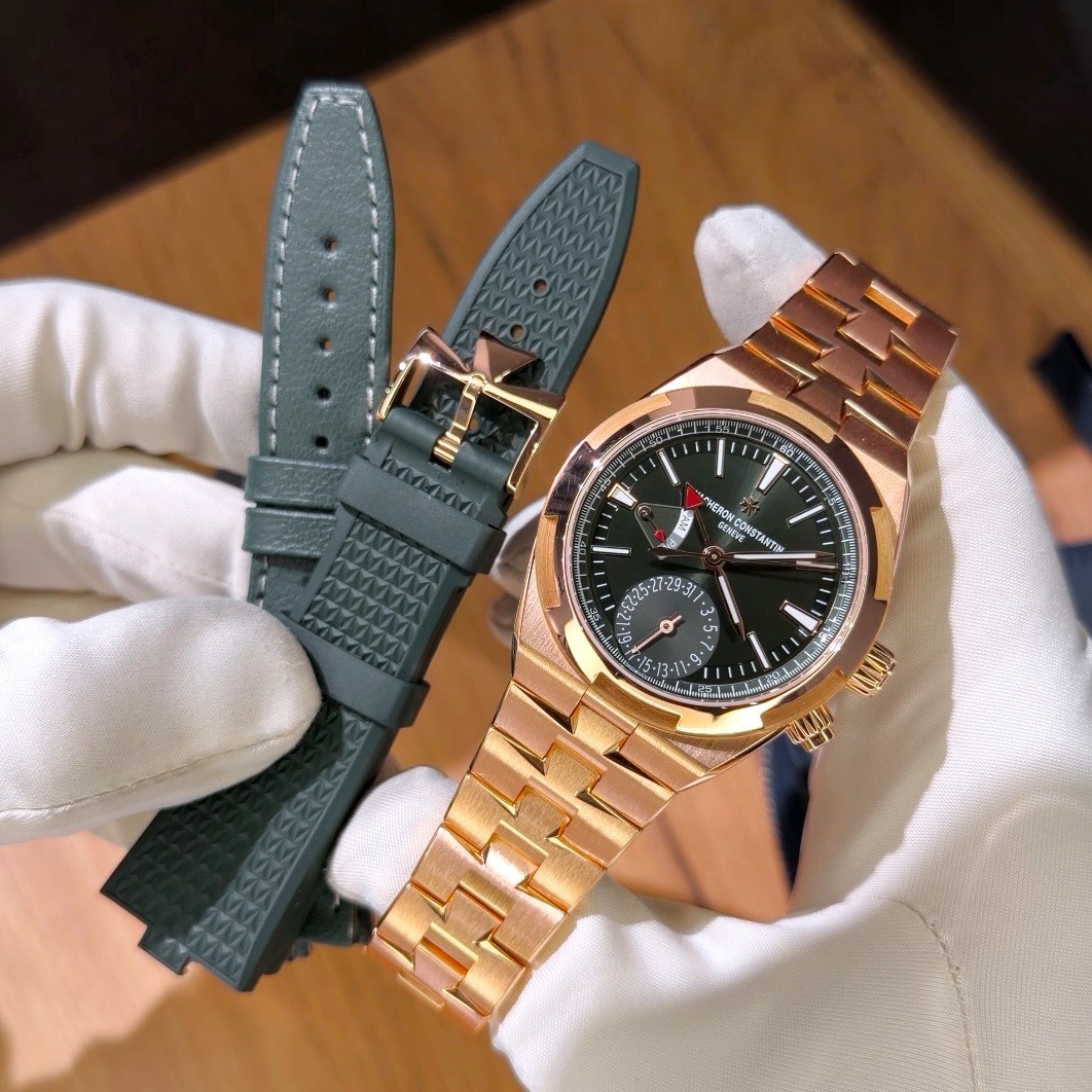 Vacheron Constantin Overseas Dual Time Sunburst Green с зелёным каучуковым ремешком Vacheron Constantin Overseas Dual Time ref. 7920V/210R-B965 на золотом браслете рядом с дополнительным зелёным каучуковым ремешком с быстрой заменой и застёжкой из розового золота
